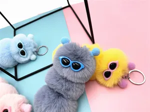 Detail view of colorful caterpillar plush keychains with cute sunglasses and rings
