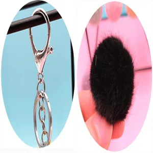 Macro detail showing the soft black plush pompom and durable silver metal lobster clasp