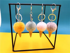Set of four colorful plush ice cream cone keychains with pom poms on a display stand