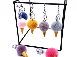 Detailed view of colorful plush ice cream cone keychains hanging on a minimalist black stand.