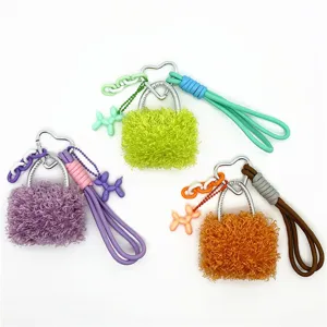 Detailed view of three colorful plush bag charms with heart clips and balloon dog pendants