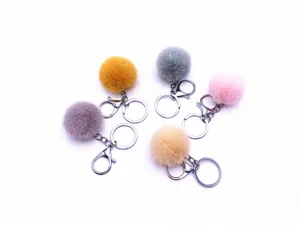 Detailed view of colorful faux fur pompom keychains in multiple soft pastel shades