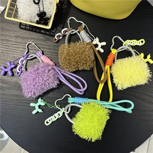 Detail view of colorful plush mini bag charms with heart carabiners and balloon dogs.