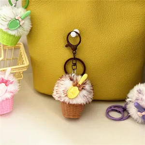 Close-up view of a fuzzy plush ice cream cone keychain with a cute decorative yellow spoon