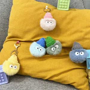 Group of colorful plush pom-pom keychains with knit hats and cute cartoon eyes hanging
