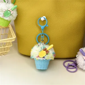 Detail view of a colorful plush ice cream cupcake keychain with a yellow spoon charm.