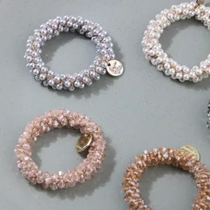 Close-up of handmade pearl and crystal beaded hair ties in various elegant colors