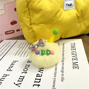Detailed macro view of a cute yellow plush ice cream charm with a colorful floral bow