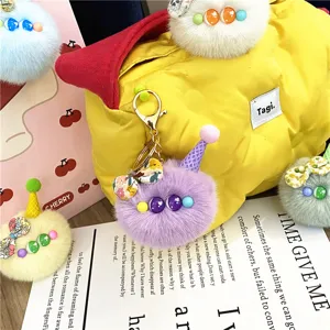 Detailed view of a purple plush monster keychain with an ice cream cone hat and floral bow