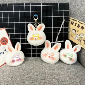 Selection of cute white plush rabbit head keychains with colorful clips on a grid background