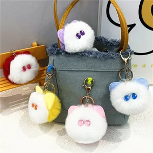 Close-up view of multiple colorful plush cat head keychains on a denim handbag accessory