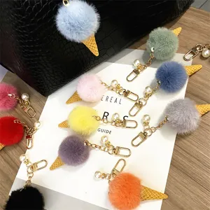 Colorful plush ice cream cone keychains with pearl charms displayed on a bag