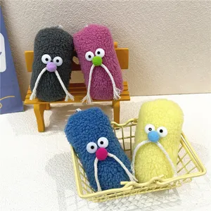 A group of colorful furry monster keychains with mustache details displayed in a mini basket.