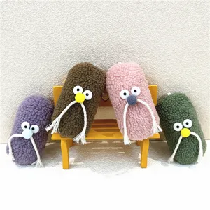Detailed view of four colorful plush mustache man keychains on a mini yellow bench