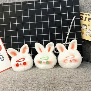 Close-up of three cute white plush rabbit head keychain charms with colorful clips