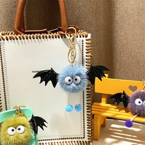 Detailed view of cute plush bat monster keychains with soft fur and black wings