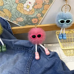 Close-up detail of creative plush ball keychains featuring cute glasses and tiny bow shoes