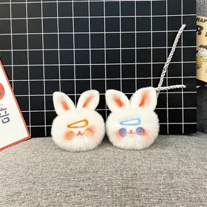 Detailed view of two cute white plush rabbit head bag charms with colorful hair clips.