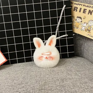 Close-up of a white fluffy bunny plush keychain with pink cheeks and a hair clip accessory.