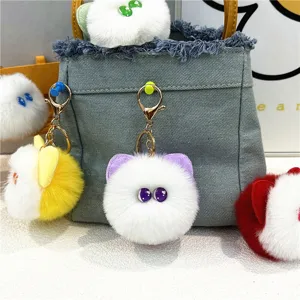 Close-up detail of cute plush cat head bag charms with soft fur and golden alloy clips
