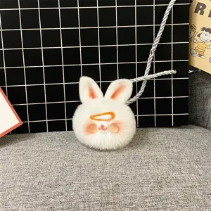 Macro view of a cute white plush rabbit keychain featuring a small orange hair clip