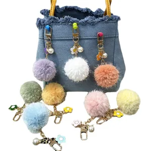 Colorful pompom keychain with cute flower and pearl charms for bags and car keys.