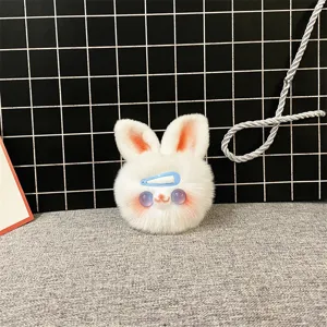 Close-up detail of a soft white plush bunny keychain with blue hairclip accessory