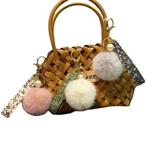 Floral ribbon keychain with cute plush pom-pom and pearl accents for bag