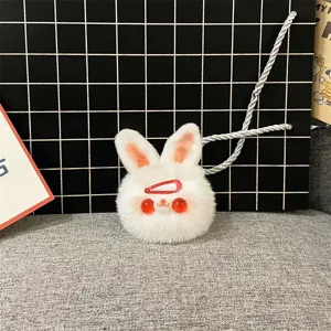 Close-up view of a cute white plush rabbit keychain with red eyes and a tiny hairclip accessory.