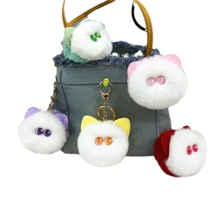 Cute plush cat head keychains in various colors attached to a denim bag
