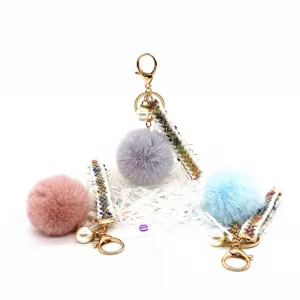 Three colorful plush ball keychains with decorative ribbons and pearls for bag charms