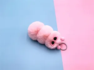 Close-up view of a cute pink plush caterpillar keychain with a soft, fluffy texture