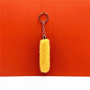 Detailed view of soft yellow fluffy faux fur keychain with polished gold-tone metal ring