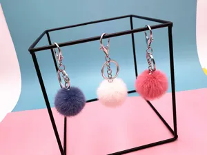 Set of three colorful fluffy pom-pom keychains as cute bag charms and car accessories