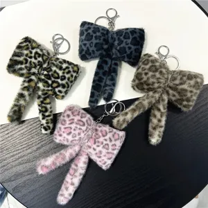 Detailed view of four cute plush leopard print bow keychains in various colors