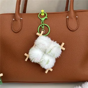 Detailed view of a creative fermented bean curd plush keychain charm on a brown leather bag