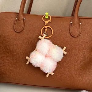 Close-up of a cute plush food-themed keychain hanging on a brown leather handbag