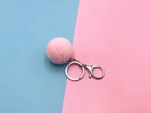 Close-up of a soft pink plush pom-pom keychain with silver metal clasp