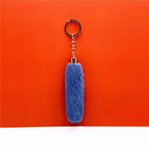 Close-up detail of a fluffy blue faux fur plush keychain pendant with a gold metal ring.