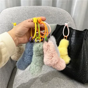 Detailed macro view showing soft plush texture and colorful loops of the bag charms