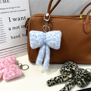 Close-up of plush leopard print bow keychain with soft faux fur texture detail