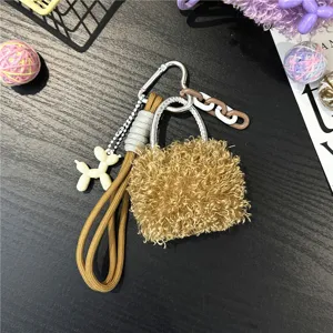 Detailed macro view of a fuzzy plush mini bag keychain featuring a cute balloon dog charm