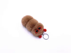 Detailed view of the fluffy brown caterpillar plush keychain featuring cute red glasses.