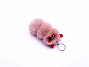 Macro detail of cute pink plush caterpillar keychain featuring trendy red sunglasses