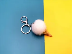 Macro view of a cute white plush ice cream cone keychain on blue and yellow background