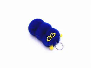 Detail shot of a cute blue plush caterpillar keychain with funny yellow sunglasses