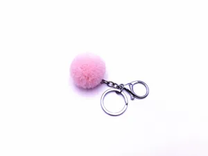 Detailed macro view of a pink faux fur pom-pom keychain accessory with a silver-toned metal clasp