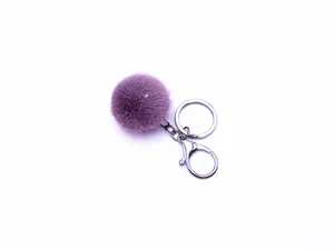 Close-up of a soft purple faux fur pom-pom keychain with a secure silver metal clasp