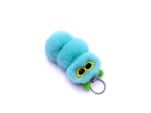 Close-up of a cute turquoise plush caterpillar keychain with yellow glasses detail.