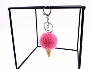 Cute pink plush pom pom ice cream cone keychain hanging on a modern stand